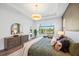 Peaceful main bedroom featuring hardwood floors, a large window with scenic views, and stylish furnishings at 8913 Bernini Pl, Sarasota, FL 34240