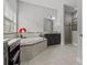 Luxurious bathroom features soaking tub, dark cabinets, granite counters and a glass-enclosed shower at 1002 Cavour Ct, Brandon, FL 33511