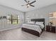 Calm and relaxing bedroom with a large window, wood-look flooring, and a ceiling fan at 1002 Cavour Ct, Brandon, FL 33511