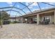 Large screened-in patio featuring pavers, ceiling fans, and outdoor seating areas at 1002 Cavour Ct, Brandon, FL 33511
