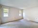 Spacious bedroom with neutral carpet and natural light from two windows at 1041 Bowsprit Ln # 1041, Holiday, FL 34691