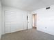 This bedroom features neutral carpet flooring and a double door closet for storage at 1041 Bowsprit Ln # 1041, Holiday, FL 34691