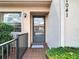 Close-up of the front door entrance, with tiled porch and freshly trimmed greenery at 1041 Bowsprit Ln # 1041, Holiday, FL 34691