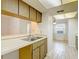 Kitchen view showcasing wood cabinets, tile floors, and a dual sink with pass through at 1041 Bowsprit Ln # 1041, Holiday, FL 34691