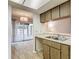 Kitchen view featuring wood cabinets, a pass-through to the living room, and tile flooring at 1041 Bowsprit Ln # 1041, Holiday, FL 34691