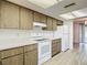 Bright kitchen with white appliances, light wood cabinets, and tile flooring at 1041 Bowsprit Ln # 1041, Holiday, FL 34691
