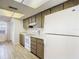 Kitchen area featuring white appliances, wood cabinetry, and tile flooring at 1041 Bowsprit Ln # 1041, Holiday, FL 34691
