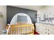 Lovely Bedroom featuring a wooden crib, a changing table, wooden shelves, and wall decorations at 10739 Shady Preserve Dr, Riverview, FL 33579