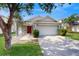 Charming single-story home featuring a red door, well-maintained lawn, and a two-car garage at 10739 Shady Preserve Dr, Riverview, FL 33579