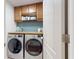 This laundry room has great natural light, wood cabinets, and modern machines at 10739 Shady Preserve Dr, Riverview, FL 33579