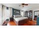 Well-lit bedroom featuring hardwood floors, a ceiling fan, built-in bookshelves, and a large window at 10739 Shady Preserve Dr, Riverview, FL 33579