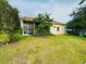 The backyard features a partially screened in porch, grassy lawn, and some shrubbery at 10806 Brookhaven Dr, New Port Richey, FL 34654