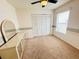 Bright bedroom with neutral carpet, a ceiling fan, closet and a mirrored vanity at 10806 Brookhaven Dr, New Port Richey, FL 34654