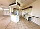 Well-lit kitchen featuring tile floors, white cabinets, stainless steel appliances, and a breakfast bar at 10806 Brookhaven Dr, New Port Richey, FL 34654