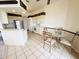 Open-concept kitchen with stainless steel appliances, a breakfast bar, and a dining area with a glass-top table at 10806 Brookhaven Dr, New Port Richey, FL 34654