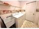 Functional laundry room featuring a washer, dryer, utility sink and overhead storage, perfect for everyday convenience at 10806 Brookhaven Dr, New Port Richey, FL 34654