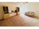 Open living room features neutral carpet, ceiling fan, large window and built-in shelving at 10806 Brookhaven Dr, New Port Richey, FL 34654
