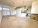 Spacious living area with carpet, tile, a ceiling fan, and a view of the open kitchen at 10806 Brookhaven Dr, New Port Richey, FL 34654