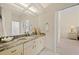 Bathroom vanity with granite countertops, a decorative mirror, and tiled floors at 11137 Woodland Waters Blvd, Weeki Wachee, FL 34613