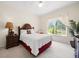Cozy bedroom features a ceiling fan, and a large window with a view of lush greenery at 11137 Woodland Waters Blvd, Weeki Wachee, FL 34613