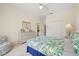 Bright bedroom features tropical bedding, a ceiling fan, and dresser with a mirror at 11137 Woodland Waters Blvd, Weeki Wachee, FL 34613