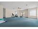 Spacious bonus room with blue carpet, fan, natural light and exercise equipment at 11137 Woodland Waters Blvd, Weeki Wachee, FL 34613