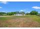 Spacious home with a long driveway, lush green lawn, and mature trees offering privacy and tranquility at 11137 Woodland Waters Blvd, Weeki Wachee, FL 34613