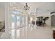 Bright and spacious foyer showcasing tile floors, elegant columns, and a grand chandelier at 11137 Woodland Waters Blvd, Weeki Wachee, FL 34613