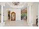 Grand foyer with soaring ceilings, tile flooring, decorative columns, and an elegant chandelier at 11137 Woodland Waters Blvd, Weeki Wachee, FL 34613
