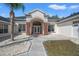 Elegant front entrance featuring a covered porch, decorative stone accents, and a beautifully landscaped yard at 11137 Woodland Waters Blvd, Weeki Wachee, FL 34613