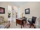 Comfortable home office with wood desk and chair, adjacent to grand foyer and dining room at 11137 Woodland Waters Blvd, Weeki Wachee, FL 34613