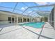 Full view of the in-ground pool with large patio and screened-in lanai and exterior wet bar at 11137 Woodland Waters Blvd, Weeki Wachee, FL 34613