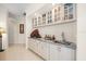 Stylish wet bar featuring granite countertops, glass cabinets, and ample storage space at 11137 Woodland Waters Blvd, Weeki Wachee, FL 34613