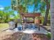 Outdoor grill and seating area under a pergola surrounded by lush landscaping at 112 W Mohawk Ave, Tampa, FL 33604