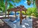 Landscaped backyard featuring a stylish pergola and outdoor seating area at 112 W Mohawk Ave, Tampa, FL 33604