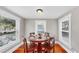 A cozy dining room with hardwood floors and a round wood table, illuminated by natural light from the windows at 112 W Mohawk Ave, Tampa, FL 33604