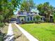 Charming two-story home with lush landscaping, mature palm trees, and a well-manicured lawn at 112 W Mohawk Ave, Tampa, FL 33604