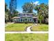 Beautifully landscaped front yard leading to a charming blue two-story home at 112 W Mohawk Ave, Tampa, FL 33604