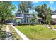 Charming two-story blue home with landscaped front yard, walkway, and gated drive at 112 W Mohawk Ave, Tampa, FL 33604