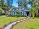Charming blue two-story home with a well-manicured front yard and walkway at 112 W Mohawk Ave, Tampa, FL 33604