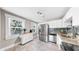 Bright kitchen with stainless steel appliances, tiled backsplash, and large windows, all illuminated by modern lighting at 112 W Mohawk Ave, Tampa, FL 33604