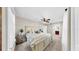 Bright main bedroom with neutral tones, carpet, a ceiling fan and comfortable bedding; ensuite bath is visible at 112 W Mohawk Ave, Tampa, FL 33604