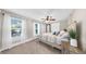 A spacious main bedroom featuring large windows, plush carpeting, a ceiling fan and comfortable bedding at 112 W Mohawk Ave, Tampa, FL 33604