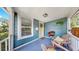Inviting front porch with seating, decorative plants, and a cheerful yellow door at 112 W Mohawk Ave, Tampa, FL 33604