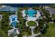 Aerial view highlighting the pool and splashpad, surrounded by trees and the lake, offering a perfect recreational space at 11550 Lake Lucaya Dr, Riverview, FL 33579