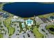 Aerial view showcasing the community's clubhouse, pool, and splashpad next to a scenic lake, perfect for Gathering fun at 11550 Lake Lucaya Dr, Riverview, FL 33579