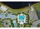 Aerial shot showcases the community pool, splashpad, and amenities bordered by green spaces and a beautiful lake at 11550 Lake Lucaya Dr, Riverview, FL 33579