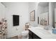 Bright bathroom featuring a floral shower curtain, decorative shelves, sleek vanity, and framed artwork at 11550 Lake Lucaya Dr, Riverview, FL 33579