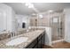 Granite countertop with dual sinks in this bright bathroom with glass enclosed shower at 11550 Lake Lucaya Dr, Riverview, FL 33579