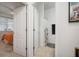 Hallway view into a bathroom with white walls and tile floors and a partially viewed bedroom with lots of natural light at 11550 Lake Lucaya Dr, Riverview, FL 33579